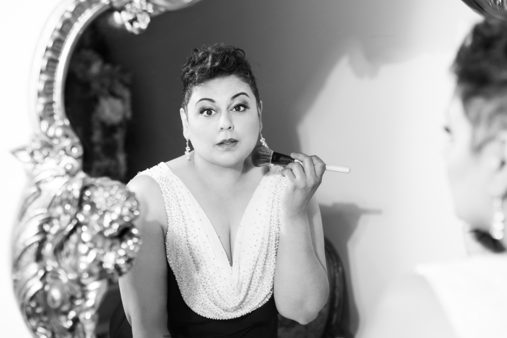 Farah in black and white at an ornate mirror