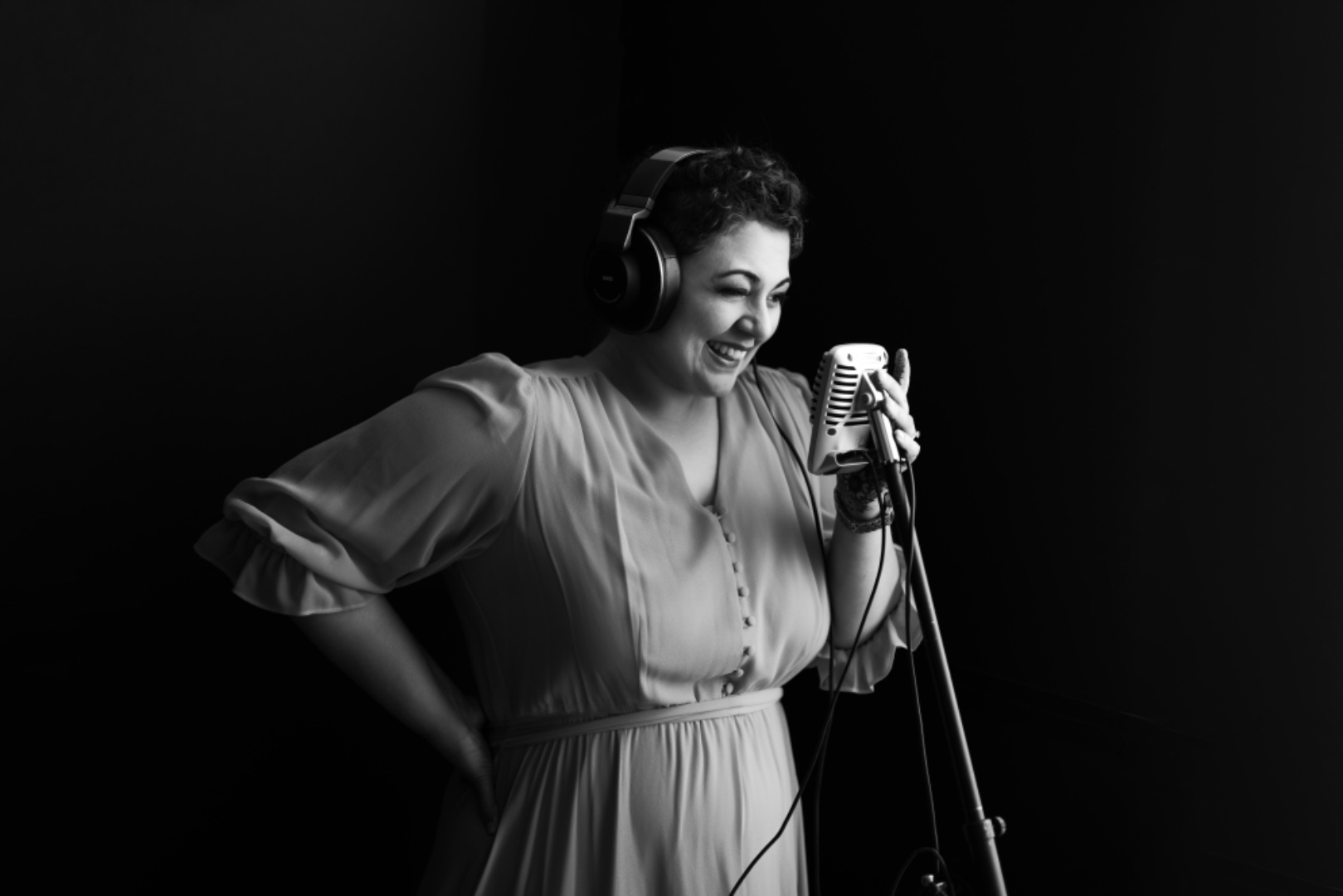 Farah at a vintage microphone with headphones, smiling mid-session